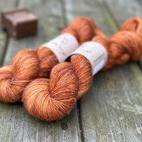 Two skeins of light orangey brown yarn with pale slubs running through them
