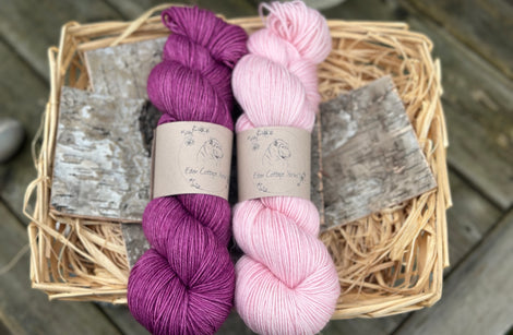 Two skeins of yarn - one purple and one pale pink