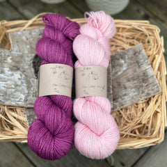 Two skeins of yarn - one purple and one pale pink