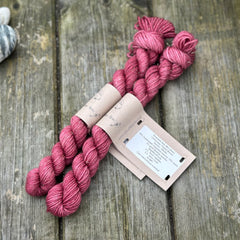 Two mini skeins of reddish purple yarn