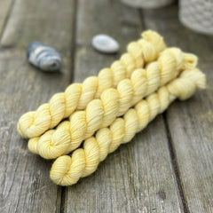 Yellow mini skeins of yarn with subtle gold sparkle running through it