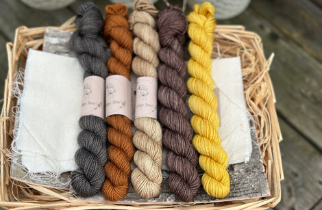Five mini skeins in shades of black, brown and yellow