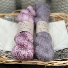 Two skeins of yarn - one pink and one fluffy purple