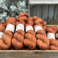 Skeins of orangey brown yarn with white linen slubs running through them