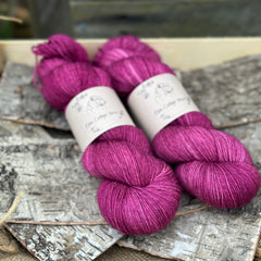 Two skeins of rich pinky purple yarn
