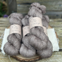 Four skeins of grey-brown yarn with silver sparkle running through it