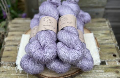 Five skeins of pale purple yarn with a silver sparkle running through it
