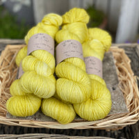 Five skeins of bright yellowy green yarn with gold sparkle running through it