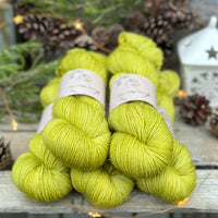 Five skeins of zingy green yarn with fine gold fibres running throughout