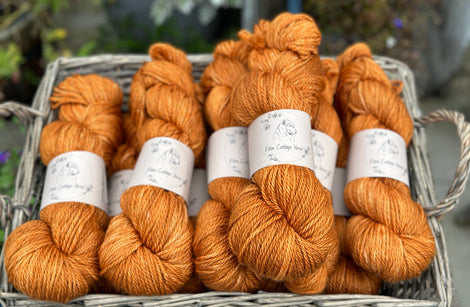 A basket of dark orange skeins of yarn