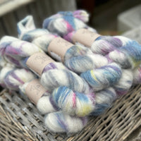 Multicoloured fluffy yarn on an upturned wicker basket.