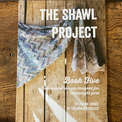 Shawl Project Book Five resting on a wooden bench 