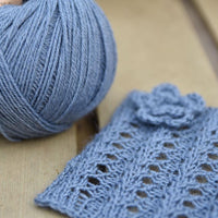 Blue yarn alongside a knitted square