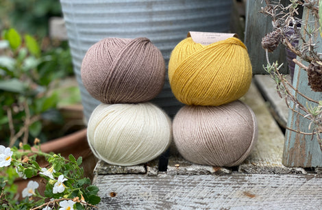 Four balls of Milburn. On the top row is a brown ball and a yellow ball. On the bottom row is a cream ball and a beige ball.
