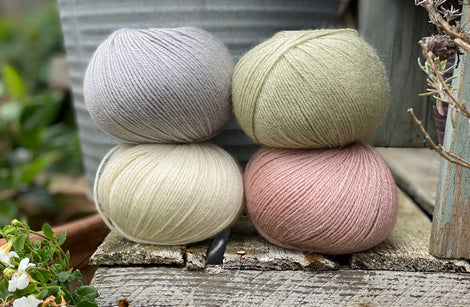 Four balls of Milburn. On the top row is a pale blue ball and a pale green ball. On the bottom row is a cream ball and a pale pink ball