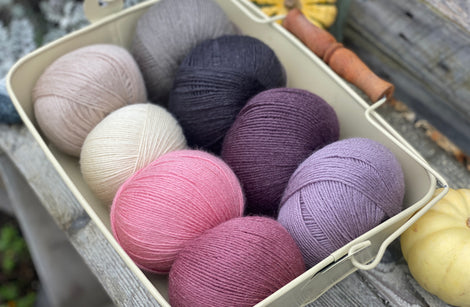 Eight balls of Milburn 4ply in shades of pink, grey and purple