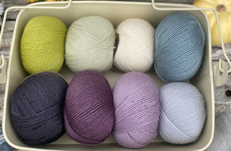 Eight balls of Milburn 4ply in shades of purple, blue and green