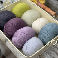 Eight balls of Milburn 4ply in shades of purple, blue and green