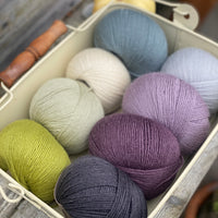 Eight balls of Milburn 4ply in shades of purple, blue and green