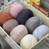 Eight balls of Milburn 4ply in shades of brown, grey and red
