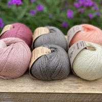 Six balls of yarn in grey and pinks