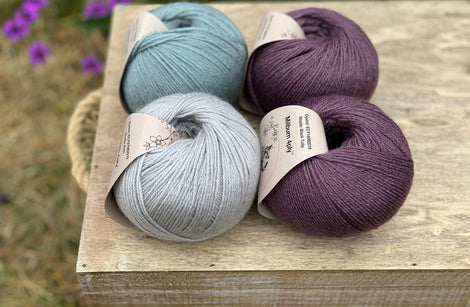Four balls of yarn in purple and blues