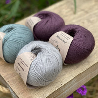 Four balls of yarn in purple and blues