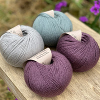 Four balls of yarn in purple and blues