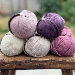 10 balls of yarn in five colours, a fade of pink/purple