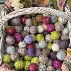 A basket of small balls of yarn in various colours