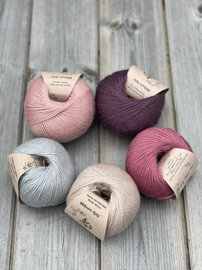 Five balls of Milburn arranged in a circle. Clockwise from top left: a pink ball, a purple ball, a dark pink ball, a beige ball and a pale blue ball