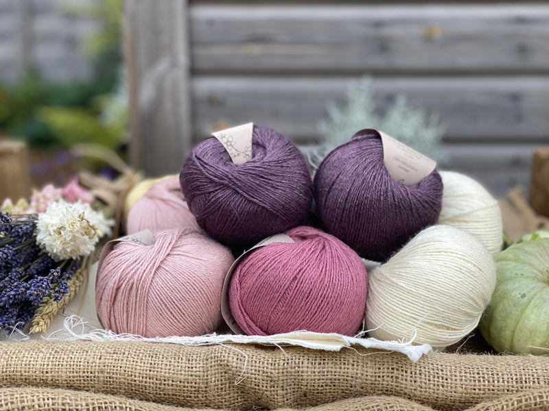 Eight balls of Milburn 4ply in shades of pink, purple and cream
