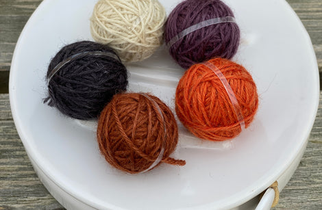 Five small balls of yarn in deep rich shades