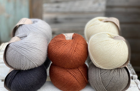Ten balls of Milburn in shades of grey with a pop of rust
