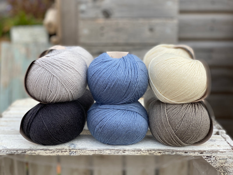 Ten balls of Milburn in shades of grey with a pop of blue