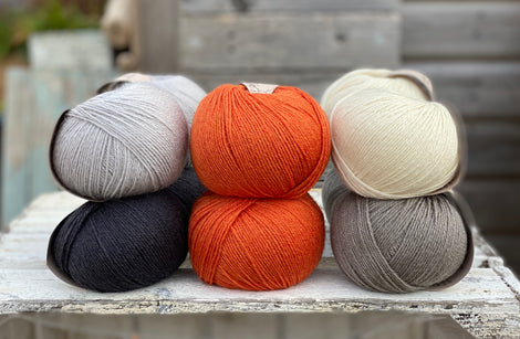 Ten balls of Milburn in shades of grey with a pop of orange