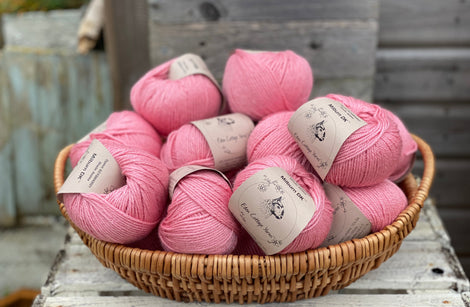 A basket filled with balls of pink yarn