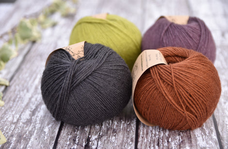 Four balls of Milburn in shades of green, purple, grey and brown