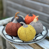 Another view of the pumpkins with the yellow one nearest the camera. It has a sparkly brown stalk. 