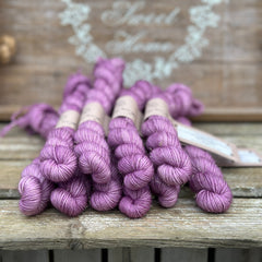 A pile of purple mini skeins with gold sparkle running through them