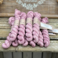 A pile of pink mini skeins with gold sparkle running through them
