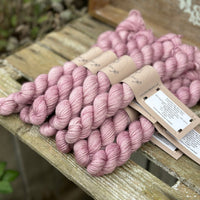 A pile of pink mini skeins with gold sparkle running through them