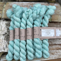 A pile of mini skeins of light turquoise yarn
