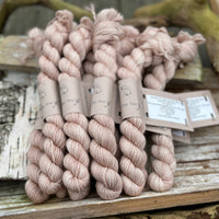 A pile of mini skeins of beige yarn