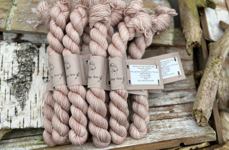 A pile of mini skeins of beige yarn