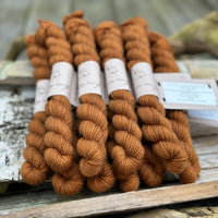 A pile of mini skeins of brown yarn