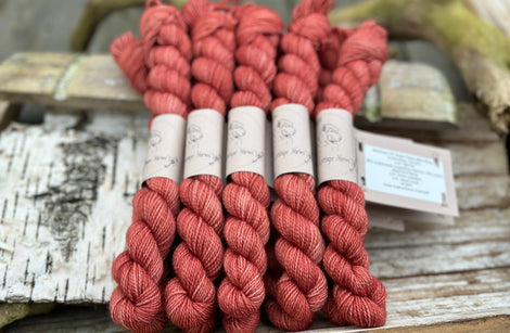 A pile of mini skeins of red yarn