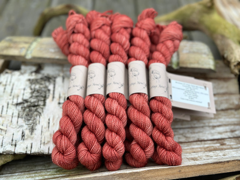 A pile of mini skeins of red yarn