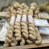 A pile of mini skeins of golden brown yarn