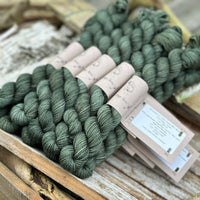 A pile of skeins of dark green yarn
